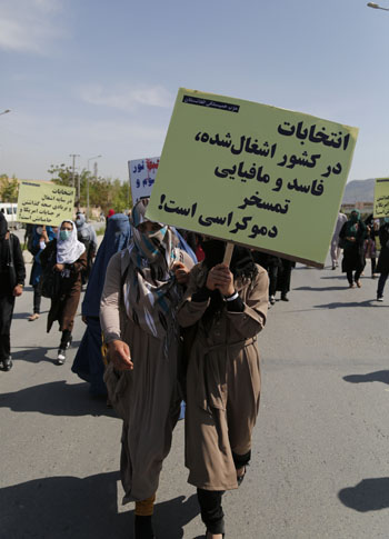 A placard in a protest by the Solidarity Party of Afghanistan’s held to condemn the dark days of 28th and 27th April reads ‘Elections in an occupied, corrupt, and mafia country is the mockery of democracy!’.