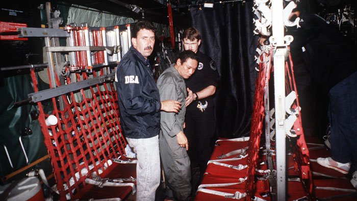 Manuel Noriega is escorted onto a U.S air force aircraft by agents from the us